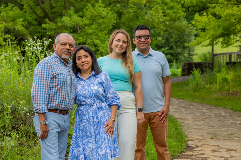 Grandparents posing together with their son and daughter-in-law along a garden path – captured by Capture Joy Photography, Northern Virginia family photographer.