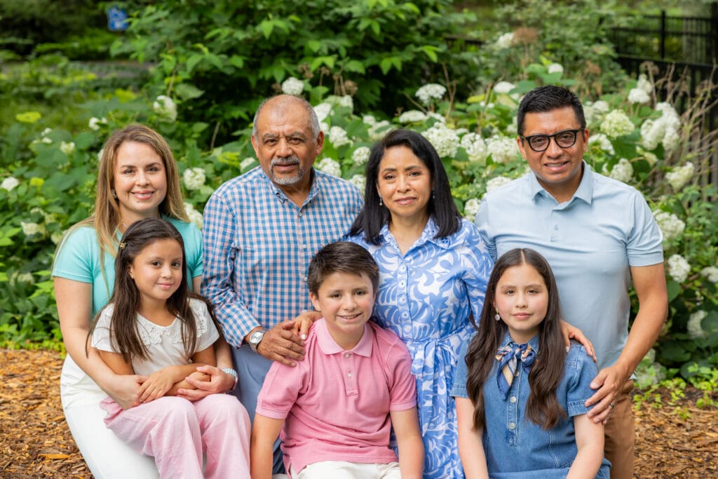 Grandparents, parents, and three children sitting together in front of lush greenery during a Meadowlark Botanical Gardens family session – captured by Capture Joy Photography, Northern Virginia family photographer.