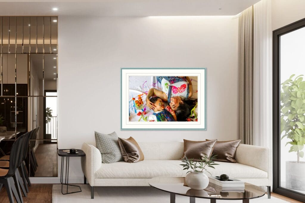 Framed photo of a joyful, paint-covered mom and son lying side by side, displayed in an elegant living room, showing how emotional, playful moments are turned into lasting art, captured by Capture Joy, Northern Virginia family photographer.